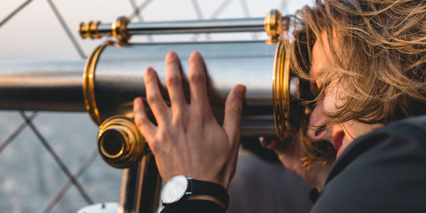 Frau mit Fernglas bei der Mitarbeitersuche